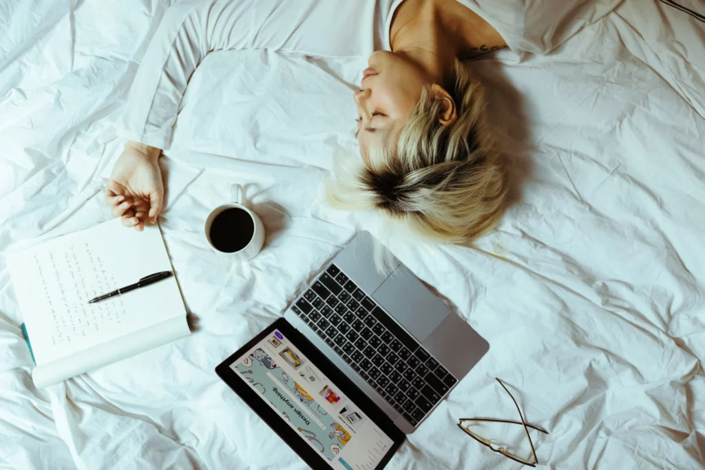 The picture shows a woman who fell asleep in bed while working