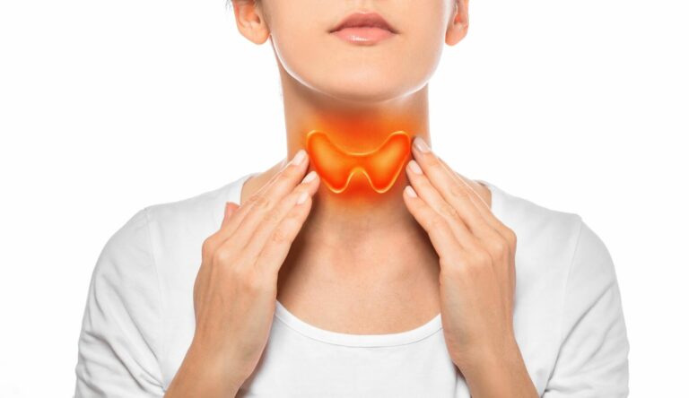 woman touches her thyroid gland