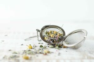 Offene Tee-Ei Kugel mit losen Kräutern darin