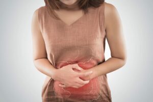 Una donna si tiene lo stomaco dolorante