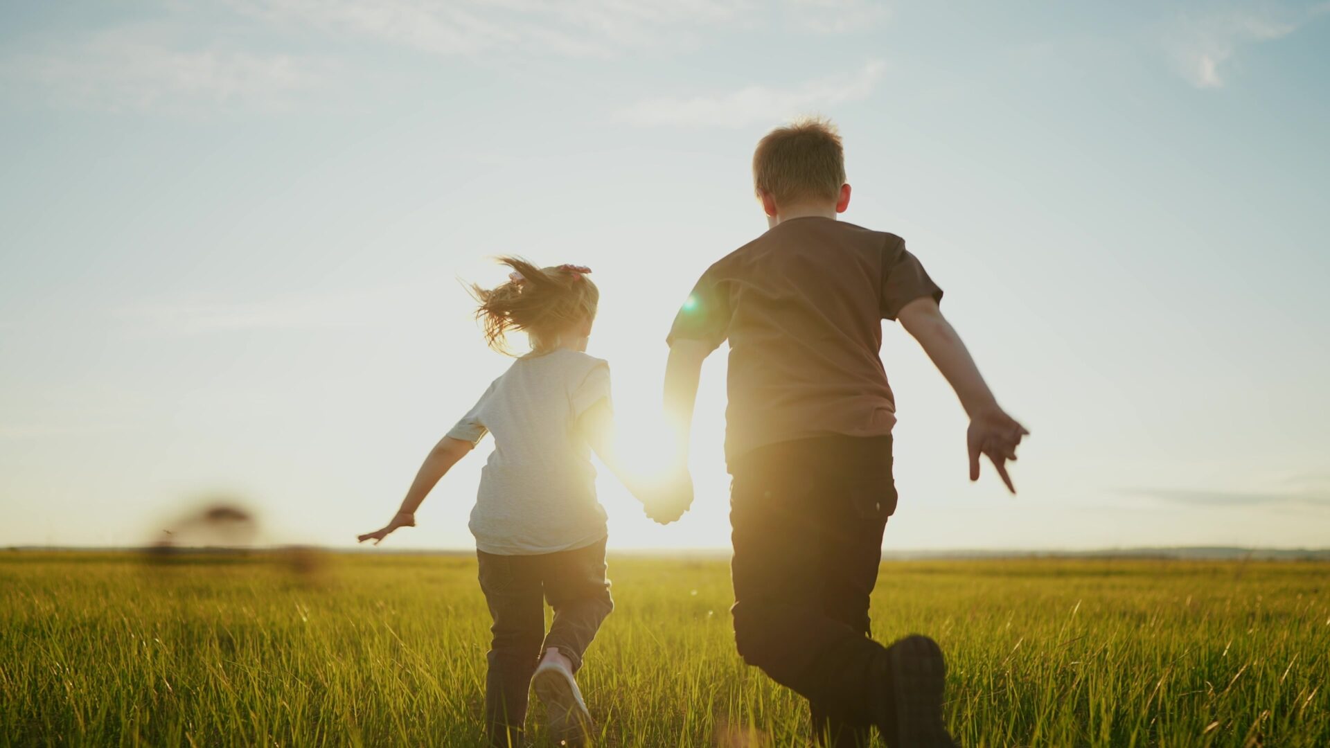 Healthy children without chickenpox run along a meadow towards the sun
